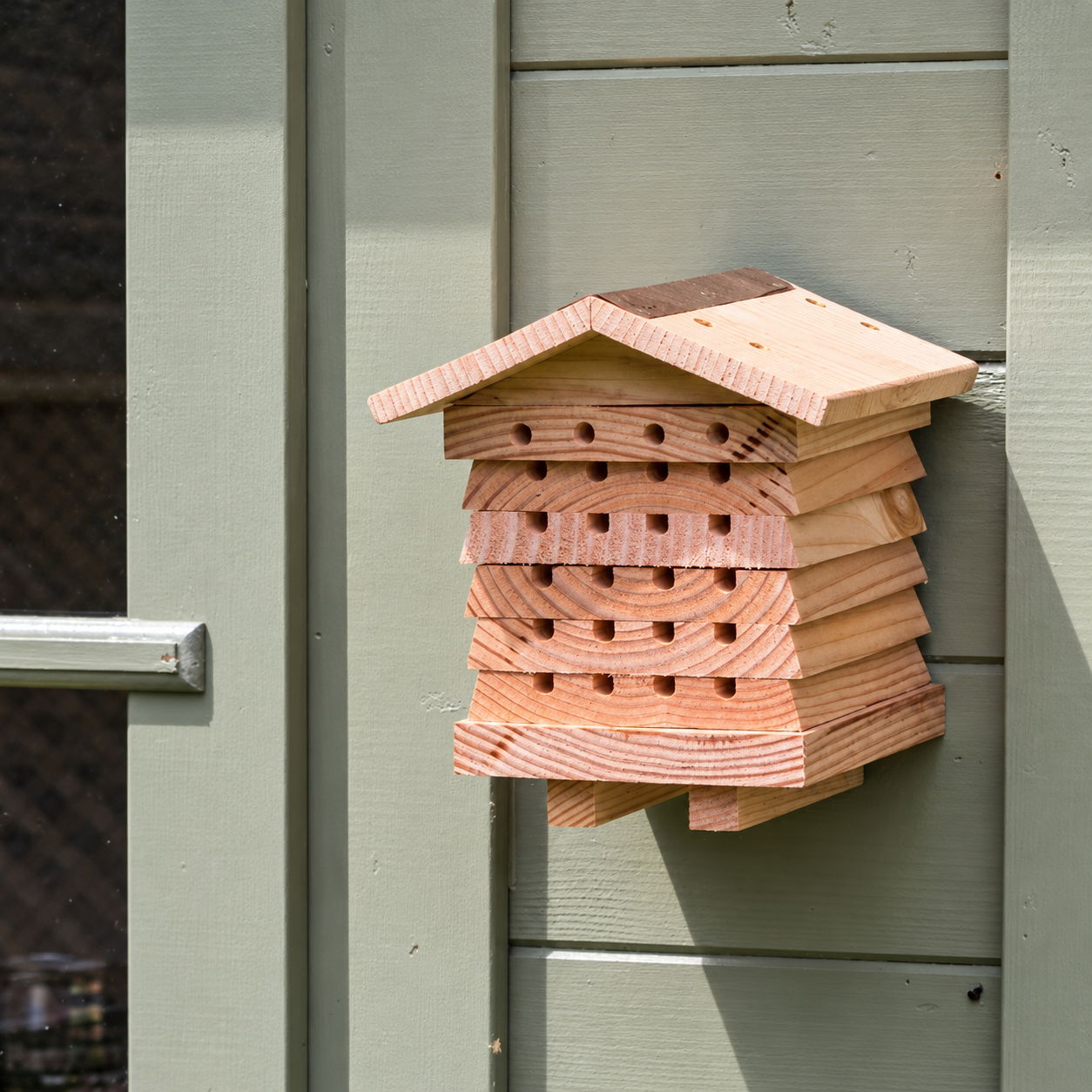 Wild Bee Hotel mounted on a painted garden wall